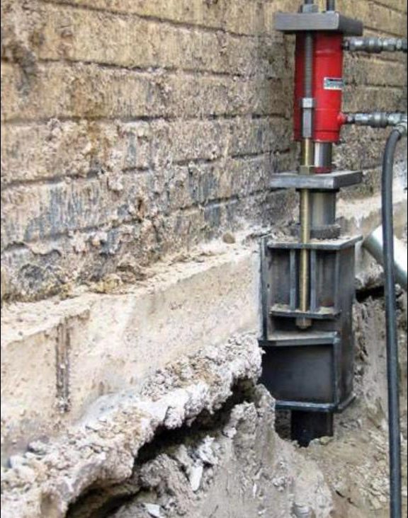 Helical pier bracket installed on a failing brick foundation